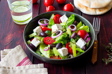 Greek salad with feta cheese, tomatoes, cucumbers, peppers and Kalamata olives. Healthy eating. Vegetarian food.