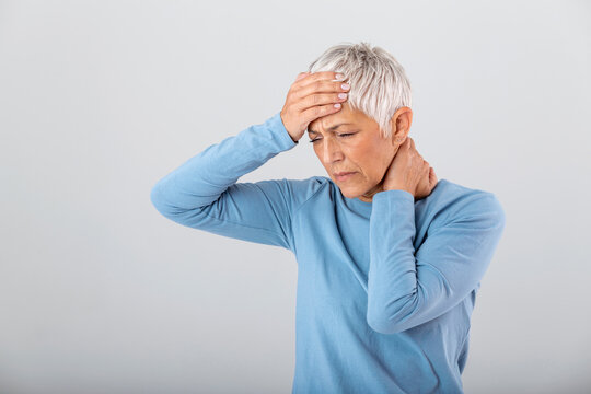 Attack of the monster migraine. Sinus pain. Unhappy Retired Senior Woman holding her head with pain expression . Face of senior woman suffering from headache