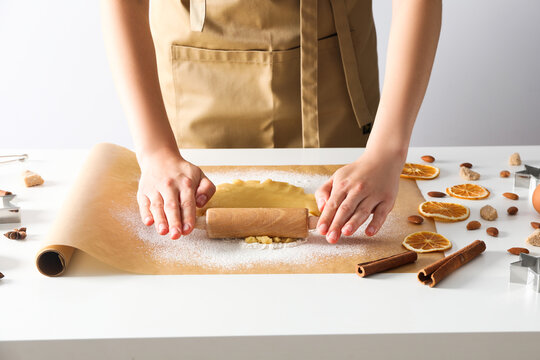 Woman cooking cookies, using cookie cutter and rolling pin