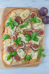 homemade pizza with Italian meat, cheese, figs, arugula, and honey