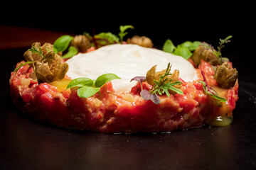 Meat carpaccio on the black plate