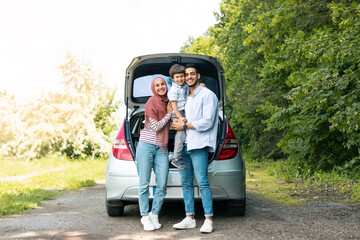 Rest outdoor from road, family journey at summer. Satisfied millennial arab man and lady in hijab