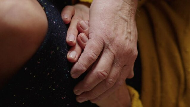 cropped view of a senior couple holding hands while resting on a couch. High quality 4k footage