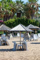 Sunbeds with sun loungers on the beach under the open sky.