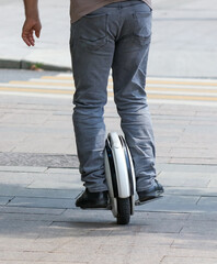 A man rides a unicycle electric bike in the city. © schankz