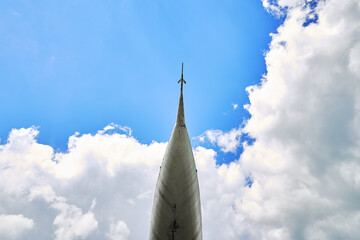 the nose of the plane on the background of the blue sky with clouds copy space