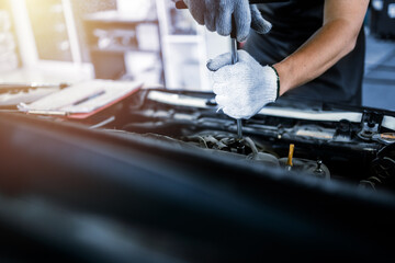 close up of view Auto mechanic repairman using a socket wrench working engine repair in the garage, change spare part, check the mileage of the car, checking and maintenance service concept.