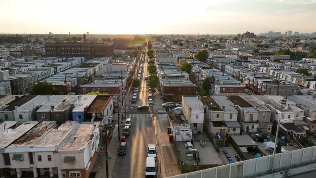 Poor urban America city housing. Low income residential district. Summer golden hour light. Aerial flight over highway to reveal street.