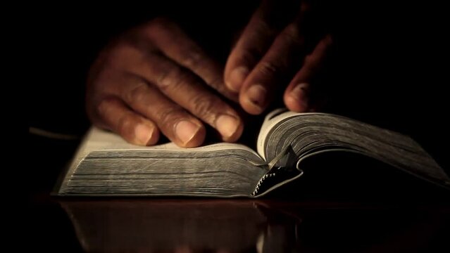 praying with hand on bible on black background with people stock footage