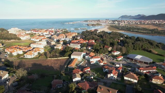 aerial view of isla, a small village in the town of cantabria and in the background noja and huge waves. forward drone shot.