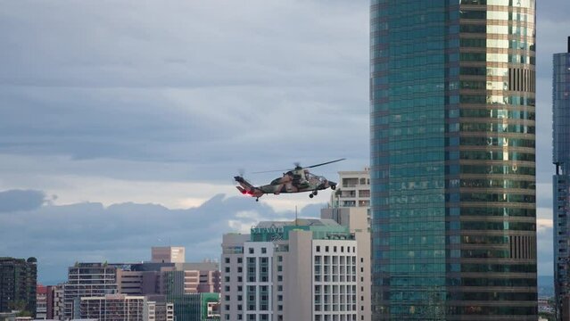 ARH Military Helicopter Waving Turret Near High Rise Building In Brisbane CBD During Riverfire, Slow Motion 4K