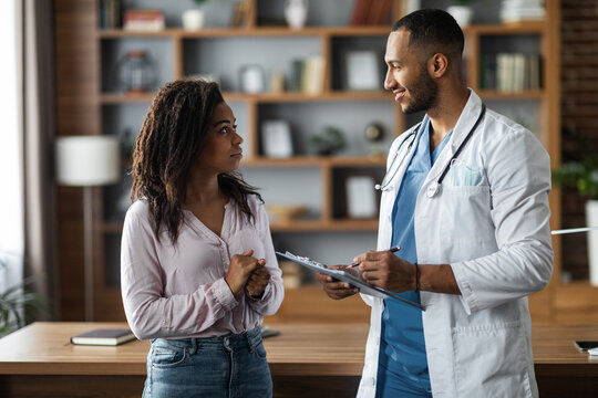 Handsome middle eastern doctor consulting african american lady patient
