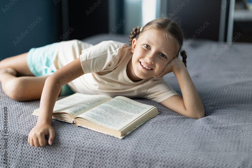 Poster Girl child reads a book in the room