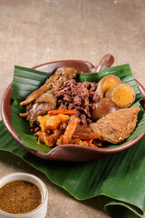 Gudeg Komplit. A Signature and Legendary Dish from Yogyakarta Indonesia. Jack Fruit Stew Accompanied with Spicy Stew of Cattle Skin Crackers and Brown Eggs, Tofu and Chicken.