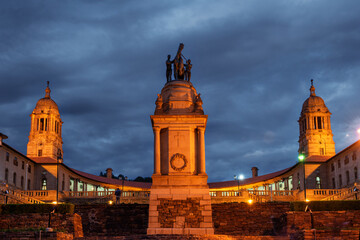 Obraz premium Evening shot of the Delville Wood memorial against a cloudy sky with the Union Buildings in the background, Pretoria, South Africa