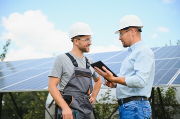 near the solar panels, the employee shows the work plan to the boss.