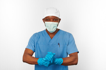 Black surgeon doctor man in blue coat white cap surgeon mask sterilizes blue gloves white background