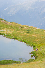 Fototapeta na wymiar un lac de montagne dans les Alpes. Un groupe de randonneurs dans les Alpes. 