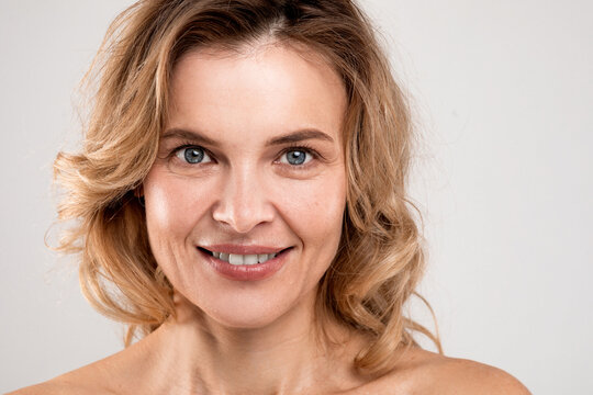 Closeup Portrait Of Smiling Attractive Middle Aged Woman With Bare Shoulders