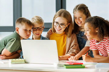 Teacher and pupils using laptop