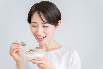 グラノーラを食べるミドル女性（朝食・食事・健康）
