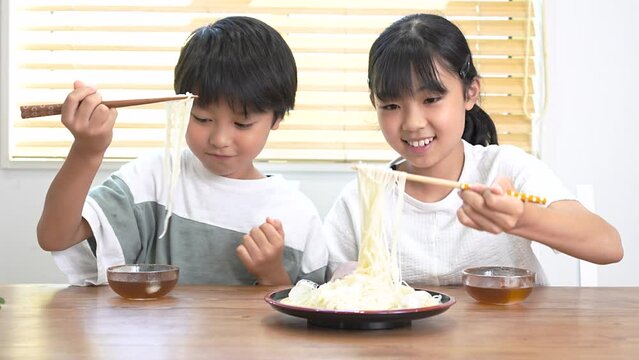自宅で素麺を食べる日本人の子供たち