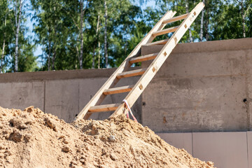 Wooden ladder lies on a construction site. Safety precautions for high-altitude work in construction.