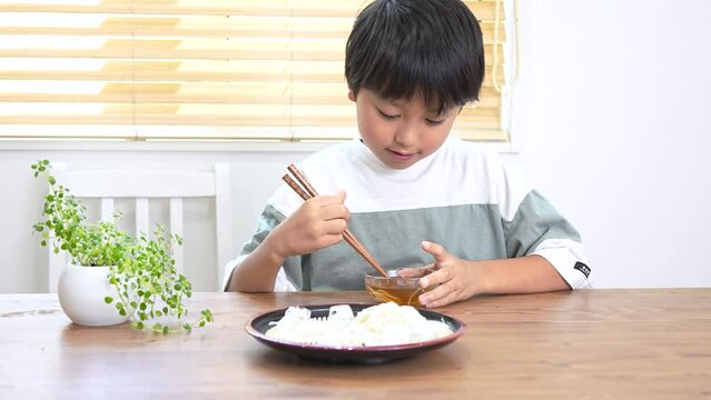自宅で素麺を食べる小学生の男の子