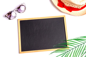 Still life: straw hat, green branch and red lifebuoy on a white background with an empty text board...