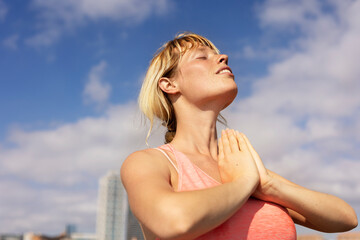 Beautiful young woman practising yoga outside. Fit woman doing stretching exercises at the beach..