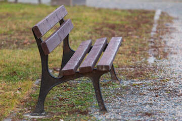 A wooden park bench on a gravel path.