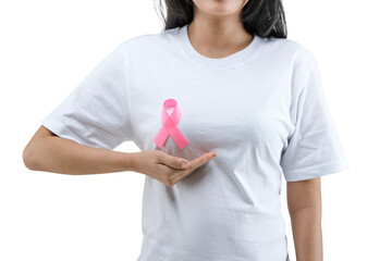 A woman in a white shirt shows a pink awareness ribbon