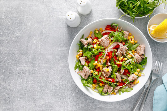 Canned tuna salad with arugula and fresh vegetables, top view