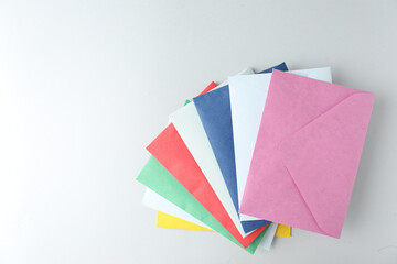 Colorful paper envelopes on light background, top view. Space for text