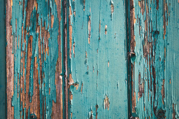 Fototapeta na wymiar Abblätternde blau grüne Farbe an einer Hauswand