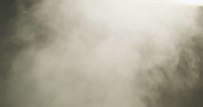 White thick smoke rises. Close-up. The gray vapor is rapidly puffing. Humidifier operation.