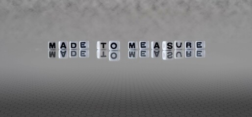 made to measure word or concept represented by black and white letter cubes on a grey horizon background stretching to infinity