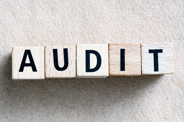 The word AUDIT arranged from wooden blocks.