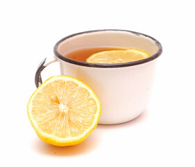 Old metal retro mug with lemon tea and a half of lemon isolated on white background.Useful beverage from autumn cold