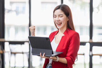 Excited happy woman looking at the tablet screen, celebrating an online win, overjoyed young asian female screaming with joy, isolated over a white blur background
