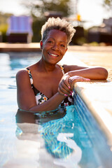 Portrait Of Smiling Senior Woman On Summer Holiday Relaxing In Swimming Pool