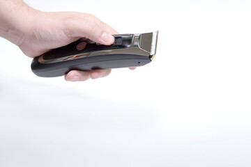 man's hand holding a hair clipper on white background
