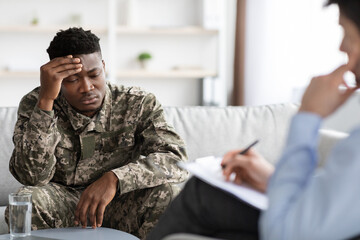 Upset african american veteran attending psychotherapist at clinic