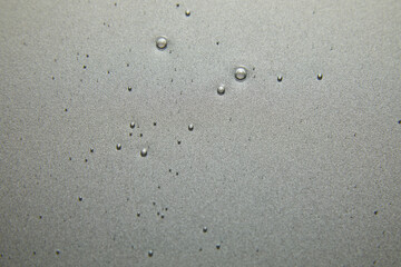 Blue cream liquid gel serum flows down on silver texture, makeup and cosmetics background, skincare or hair product