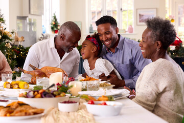 Fototapeta na wymiar Multi-Generation Family Celebrating Christmas At Home With Grandfather Serving Turkey
