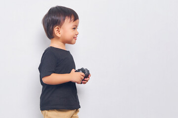 Cheerful child kid boy 2 years wearing black t-shirt play pc game with joystick console isolated on...