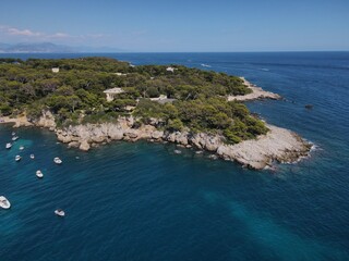 Fototapeta na wymiar Aerial view of Cap d'Antibes and Billionaire's Bay. Beautiful rocky beach near coastal path on the Cap d'Antibes, Antibes, France. Drone view from above of Côte d’Azur near Juan-les-Pins and Cannes.