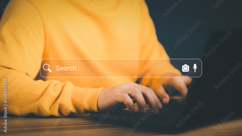 Poster Freelance's hand working with computer laptop on desk in home. Searching Browsing Internet Data Information with blank search bar. Search Engine Optimization SEO Networking Concept.