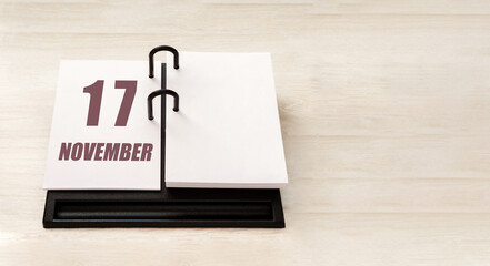 november 17. 17th day of month, calendar date. Stand for desktop calendar on beige wooden background. Concept of day of year, time planner, autumn month
