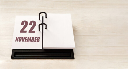 november 22. 22th day of month, calendar date. Stand for desktop calendar on beige wooden background. Concept of day of year, time planner, autumn month